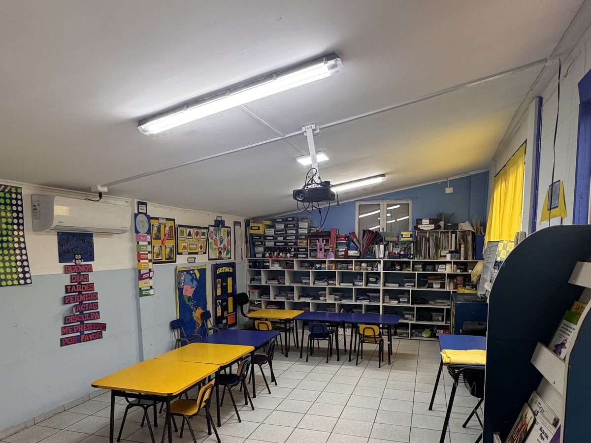 Rincón de biblioteca con estantes de cuentos y mesas de lectura