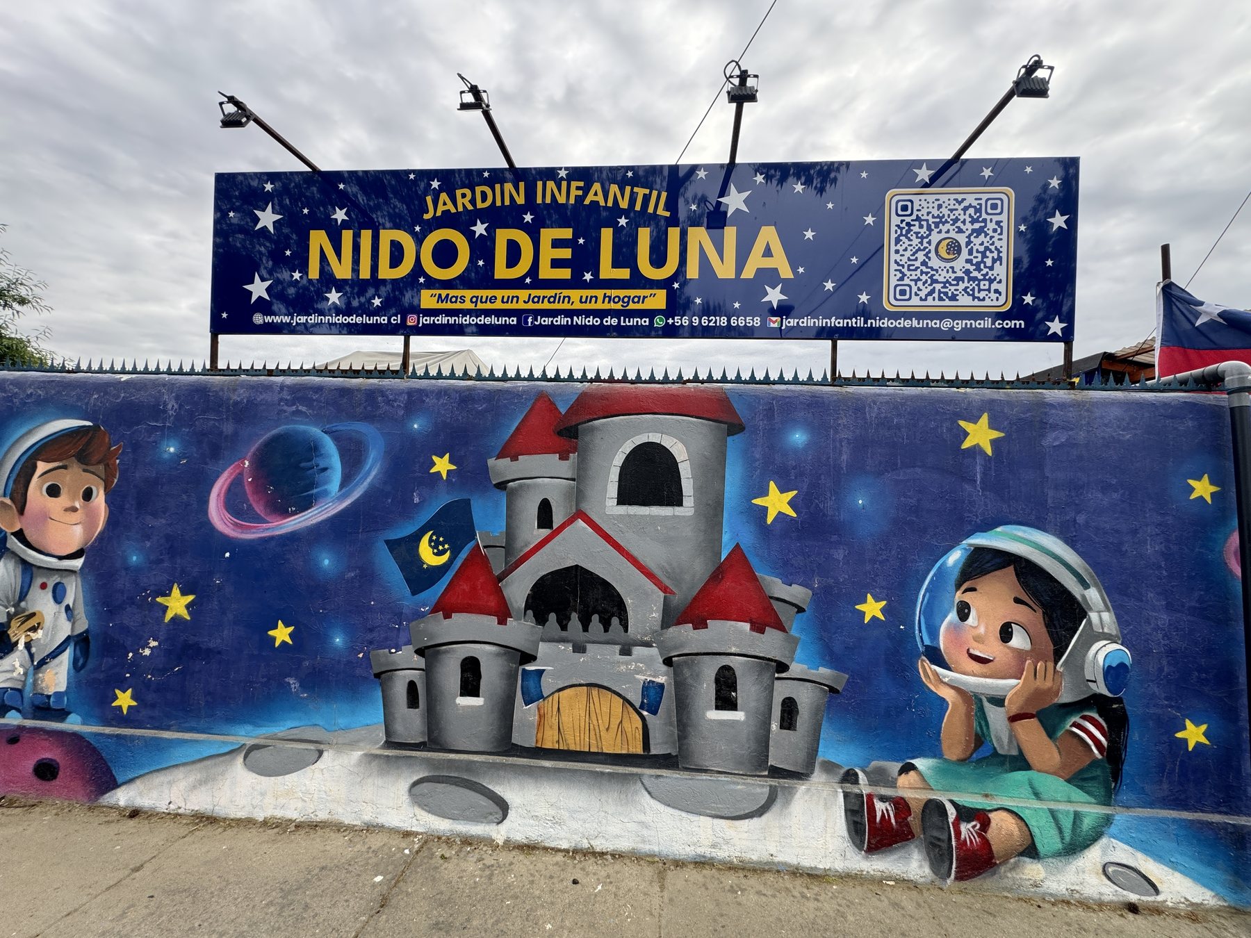 Frontis del Jardín Infantil Nido de Luna: mural de un castillo en la luna con niños astronautas y el letrero del jardín