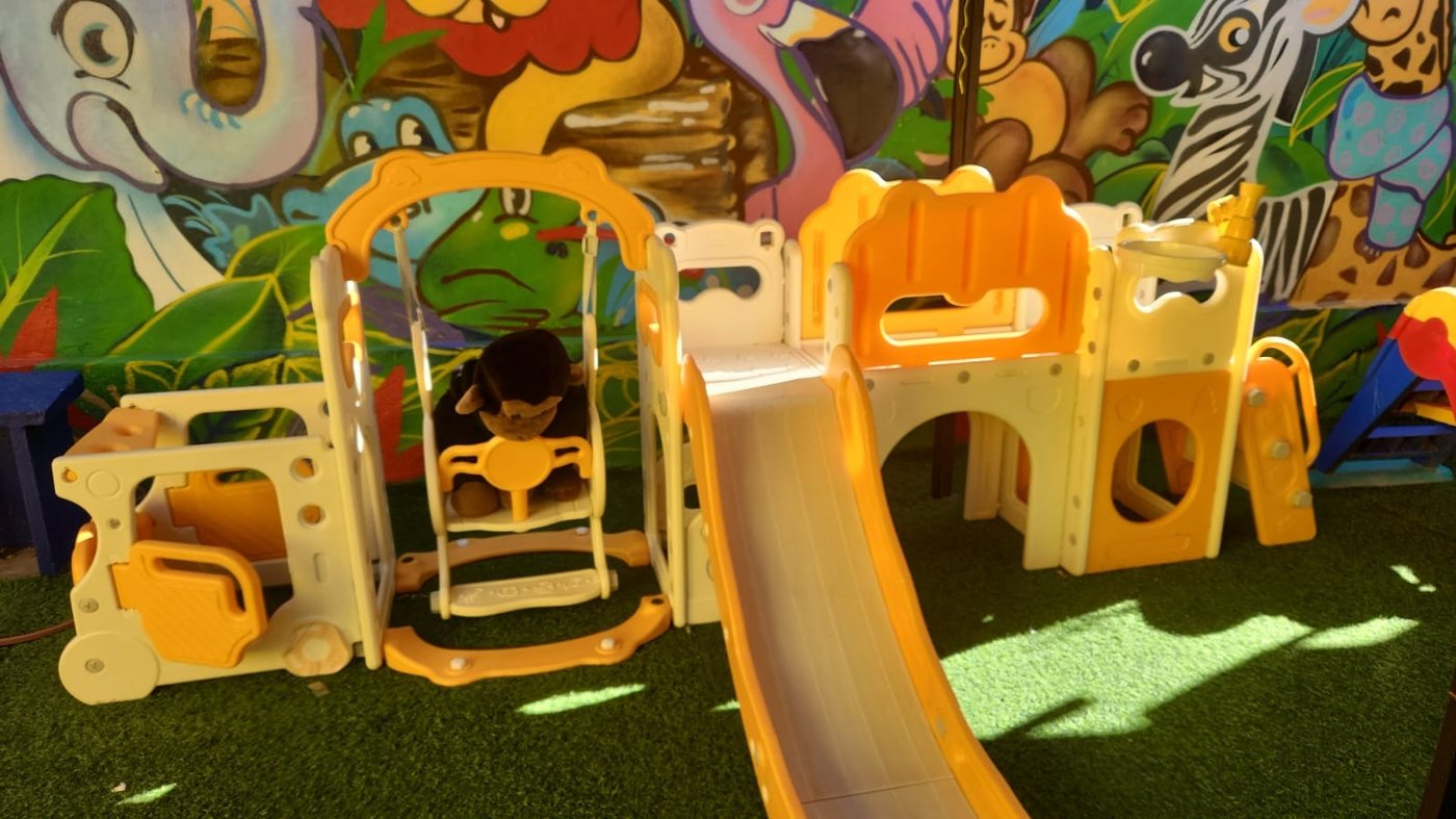 Juegos de patio con resbalín sobre pasto sintético